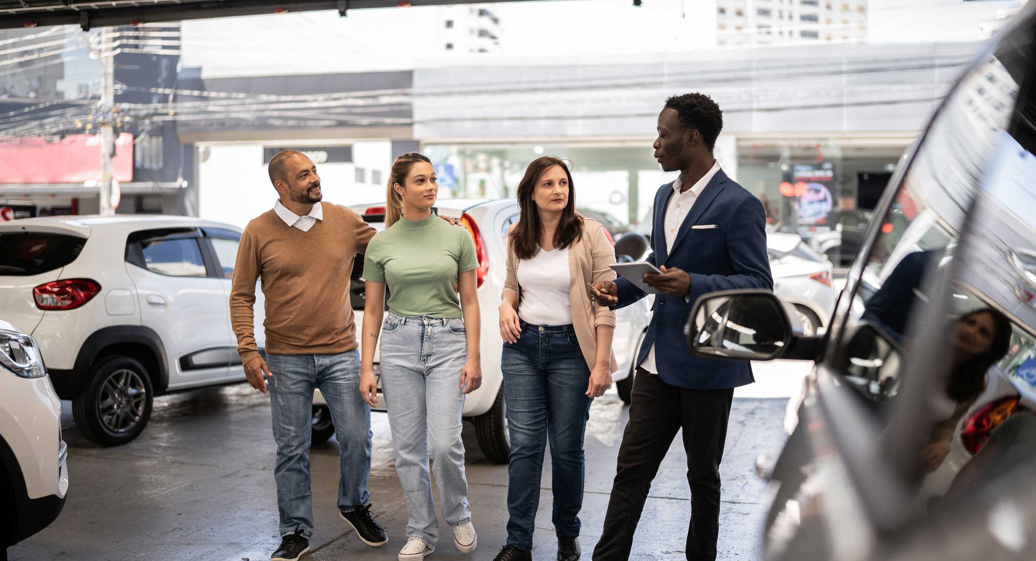 Family Working with a Sales Rep at a Car Dealership